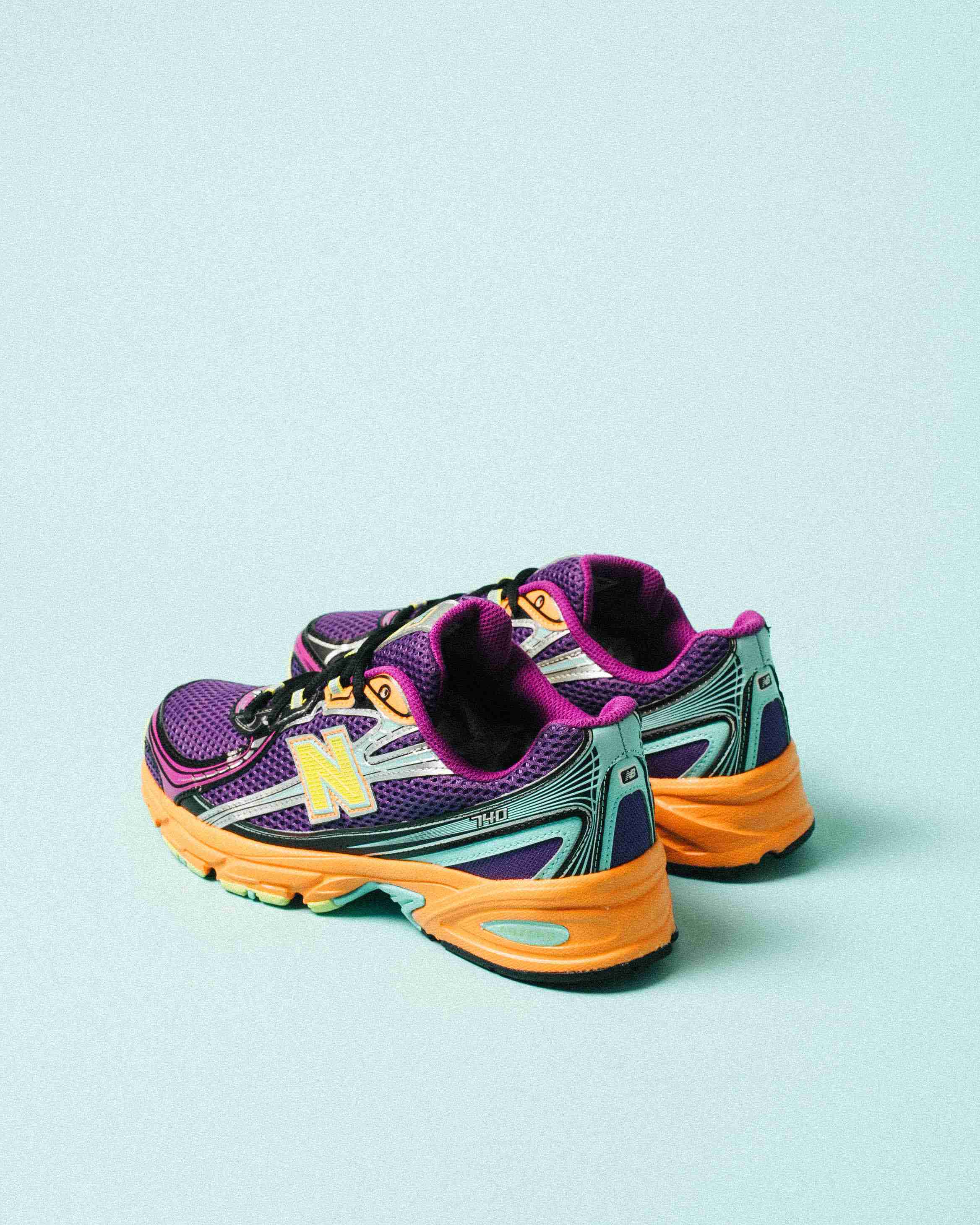 Paire de sneakers multicolores posée sur un fond clair, vue de trois quarts mettant en avant les formes et détails du modèle.